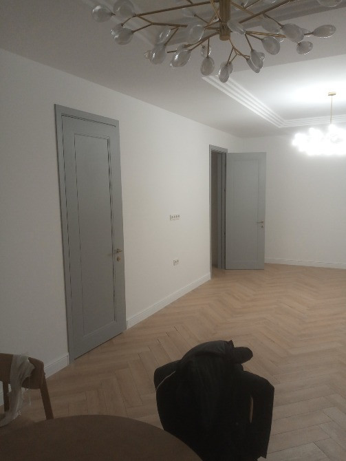 Сұр есіктер мен ағаш едені бар дәліз