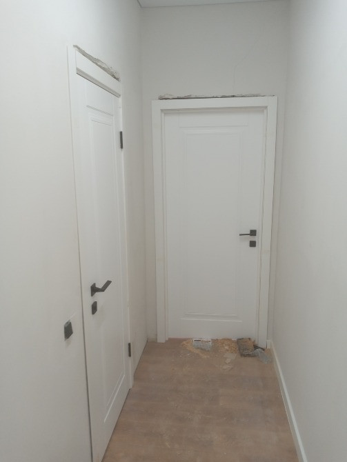 Басқа есіктің қасында дәліздегі ақ есік