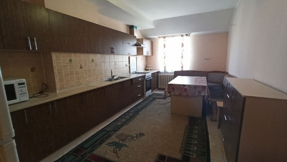 Кухня с деревянными шкафами и столом