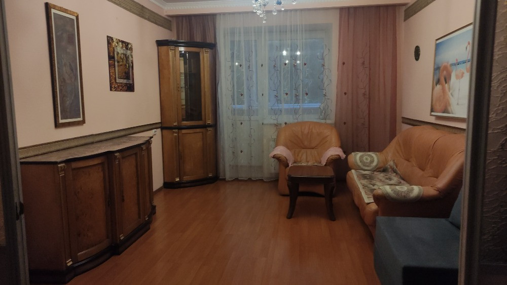 Ағаш Möbelдермен безендірілген қонақ бөлмесінің интерьері, жұмсақ дивандар мен безендіруші элементтер.