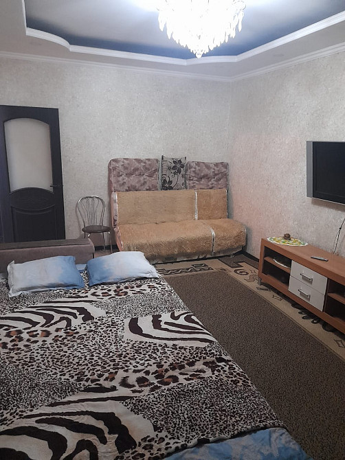 Комната с кроватью, диваном и телевизором на стене