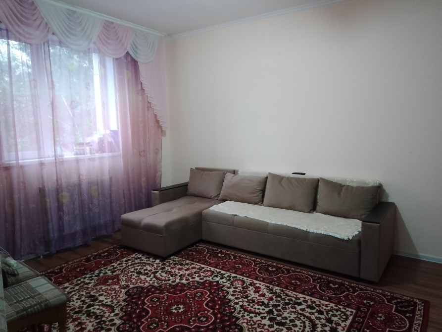 Гостиная с угловым диваном и мягким ковром