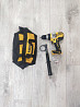 Электродрель Dewalt аксессуарларымен және құрал сумкасымен, ағаш еденде орналасқан.