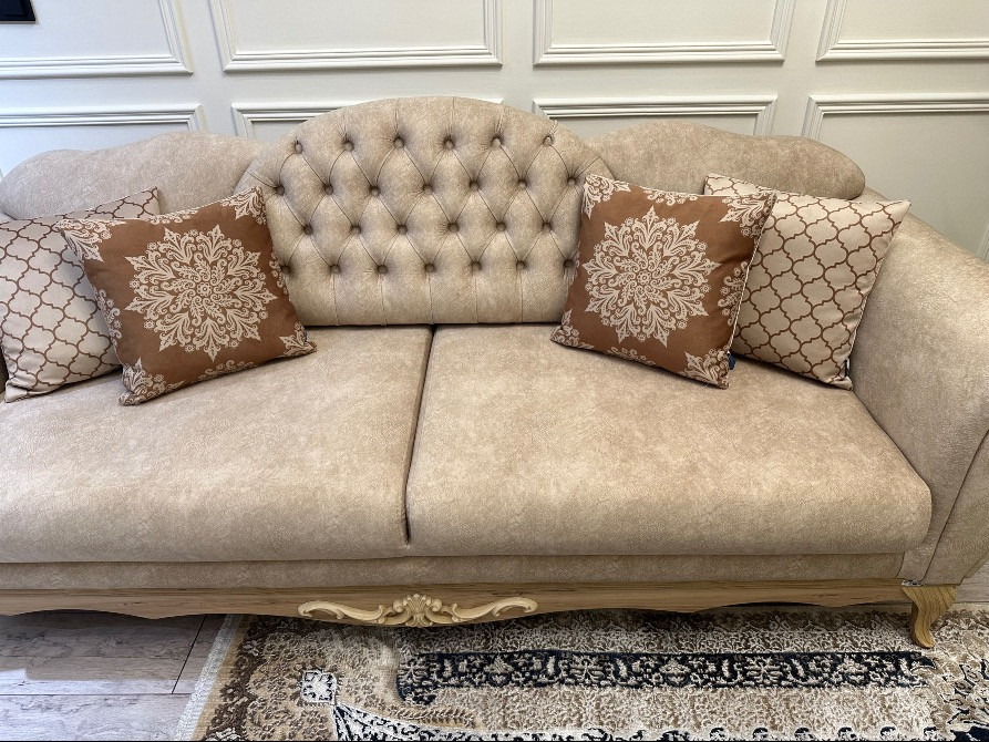 Сәнді бежевый диван жастықтармен және сәндік безендірумен