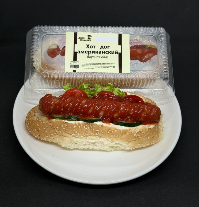 Американдық хот-дог, кетчуп және жасылмен ақ табақта