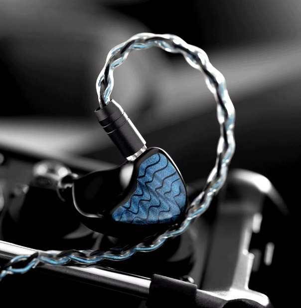 Наушники с кабелем, обернутым в прозрачную оплетку, на черном фоне