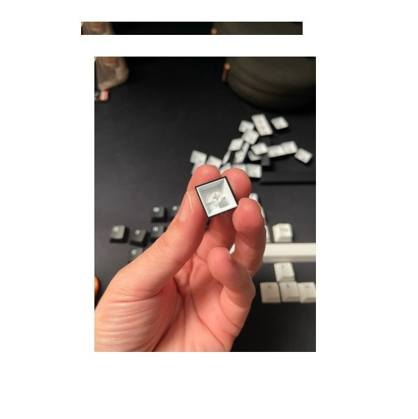 Ручка с одним клавишным колпачком на фоне множества клавиш