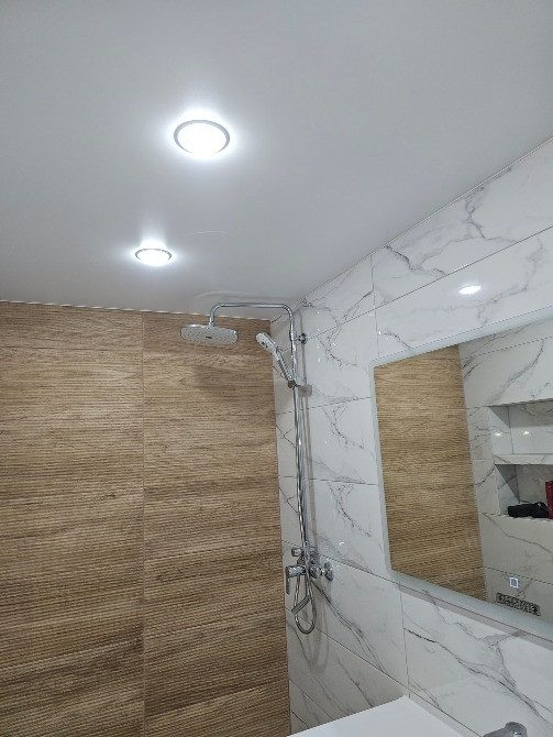 Ванная комната с душем, плитка под дерево и большой зеркалом