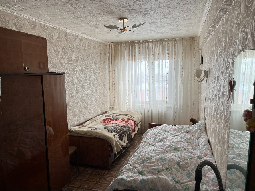 Екі кереуеті, терезелері мен айнасы бар жатын бөлме