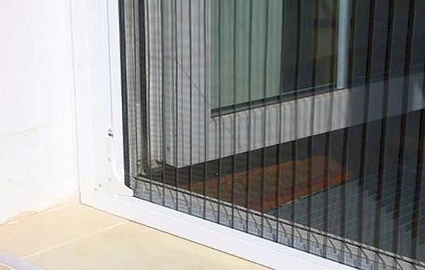 Терезеге көрінетін қара сызықтары бар москиттік торды орнату