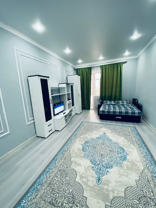 Современный интерьер спальни с кроватью и телевизором