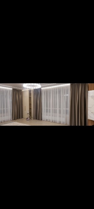 Уютная комната с бордовыми шторами и стильной люстрой