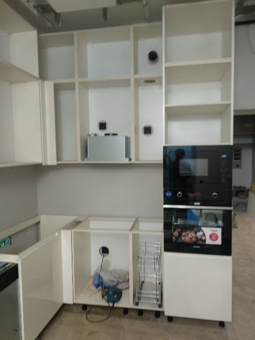 Современная кухня с незавершенной сборкой и техникой