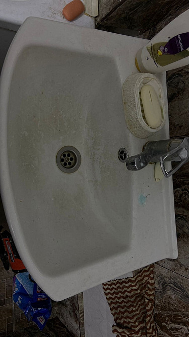 Умывальник с загрязнениями и моющими средствами рядом