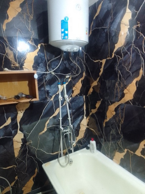 Ванная комната с электрическим водонагревателем и ванной