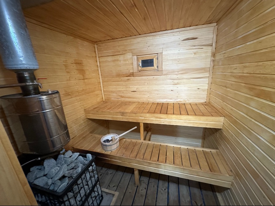 ағаш сөрелері мен тастармен сауна