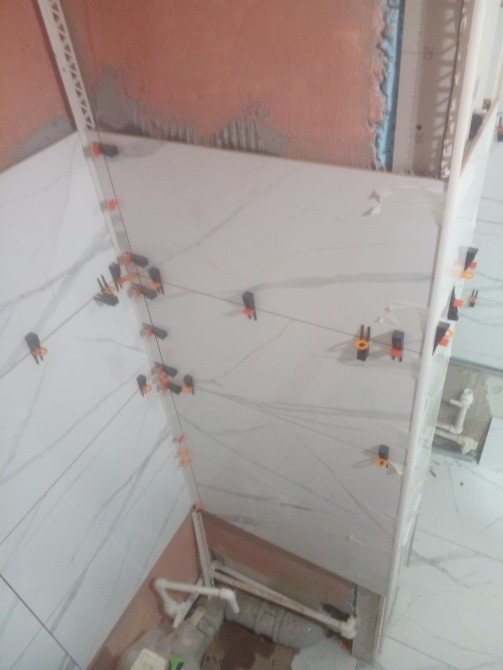 Ванна бөлмесінде плитканы дұрыс тегістеу үшін қысқыштармен орнату