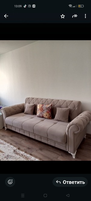 Бежевый түсті диванмен подушкалар