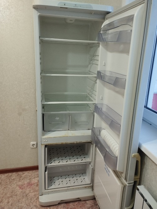 Ашық тоңазытқыш, сөрелері мен жәшіктері бос, қабырғаға орналастырылған