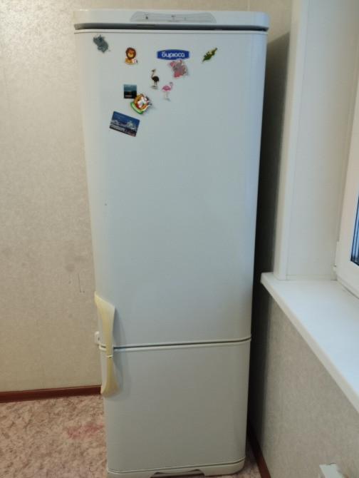 Сыртында жапсырмалары бар тоңазытқыш, терезе жанында орнатылған