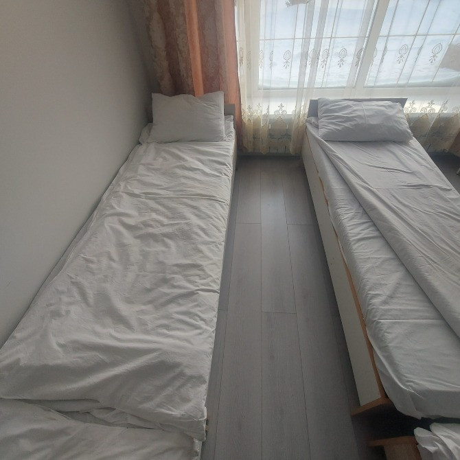 Екі бір орынды төсек терезелері бар бөлмеде, жарық және жайлы