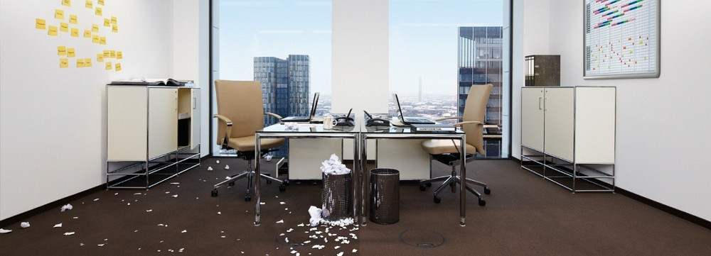 беспорядок в офисе с мусором на полу и пустыми корзинами