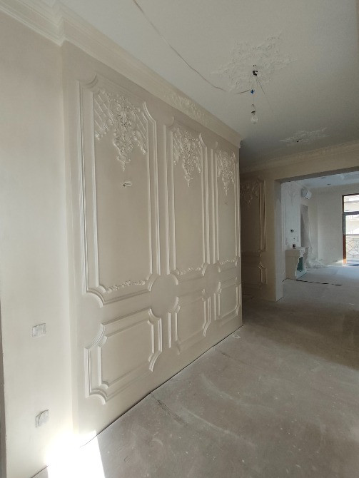 Классикалық стильде рельефті декормен безендірілген қабырға