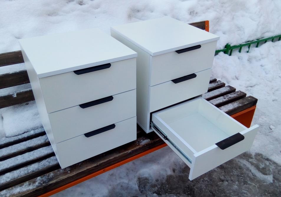 Екі ақ тумбочка үш жәшігімен және бір ашық жәшігімен