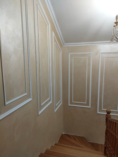 Стена лестницы с вертикальными панелями и молдингами