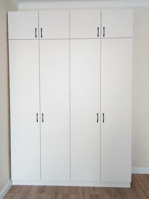 Белый шкаф с высокими дверцами и черными ручками