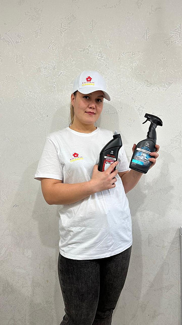 Тазалау құралдарының бөтелкелерімен қыз