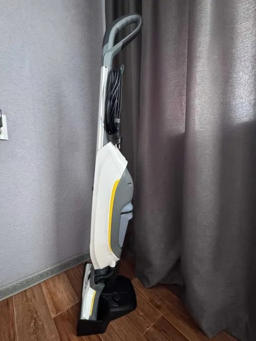 Пылесос в вертикальном положении у стены