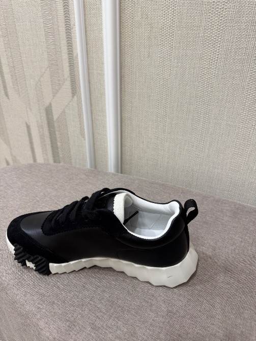 Қара кроссовкалардың ақ табаны бар бүйірден көрінісі