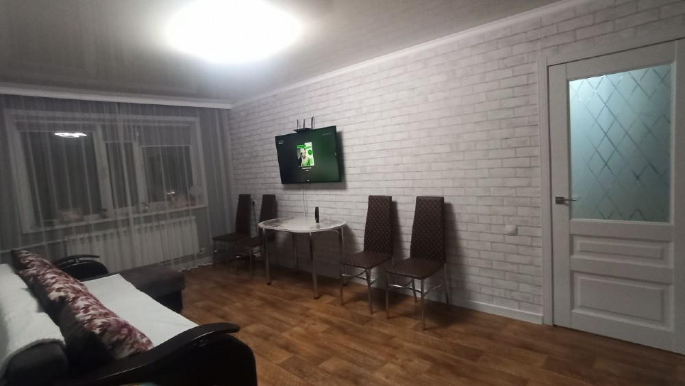 Гостиная с телевизором и обеденным столом