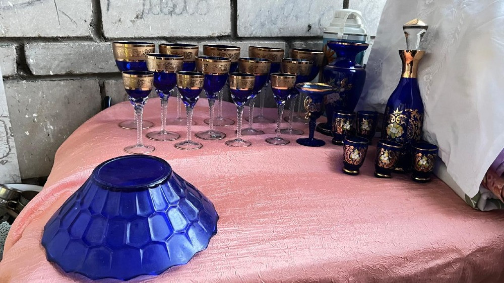 Көк шыны қызмет көрсету жиынтығы алтын безендірумен үстелде