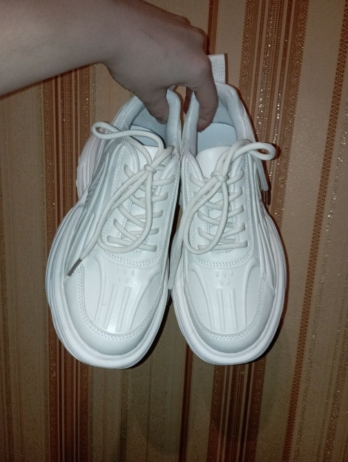 Белые кроссовки с поднятым языком и стильным дизайном