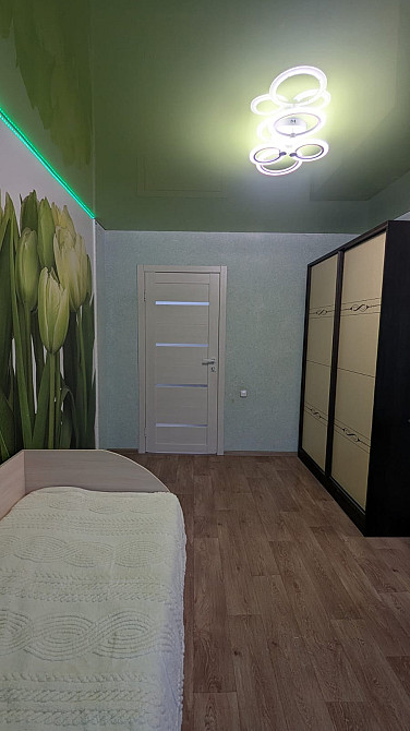 Уютная комната с зеленым потолком и росписью цветков на стене