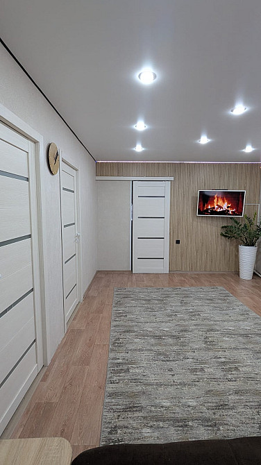 Современный интерьер комнаты с несколькими дверями и искусственным освещением