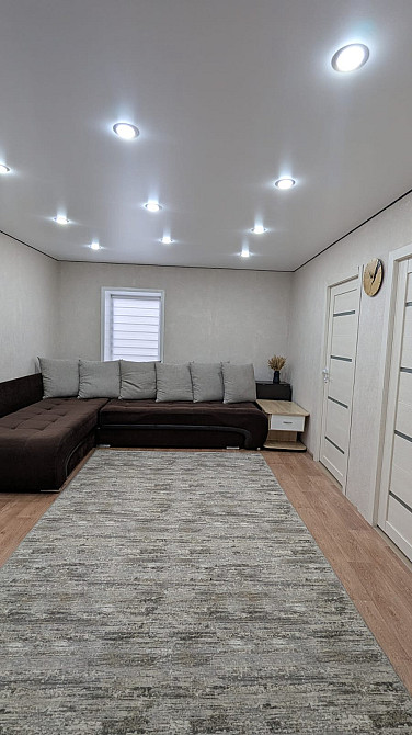 Просторная гостиная с большой угловой диваном и светлыми стенами