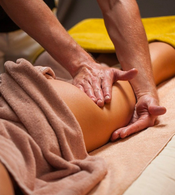 Массажная процедура, расслабляющий массаж спины, руки массажиста на бедре клиента, спокойная атмосфера