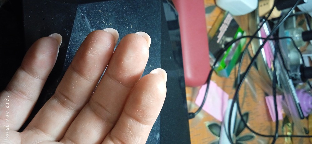 Показаны руки с ухоженными ногтями разных дизайнов и цветовых решений, на фоне рабочего стола с проводами и предметами