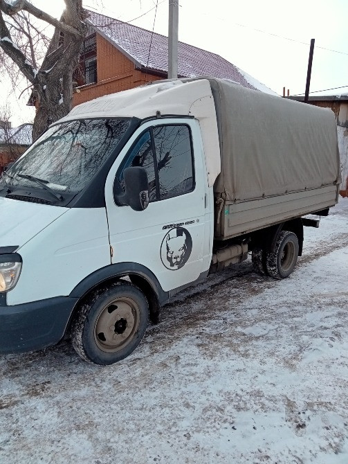 Грузовик с тентом паркованный на снежной улице