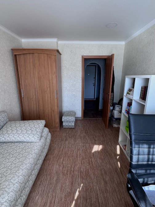 Бөлме төсек пен шкафпен, коридорға кіреберіс