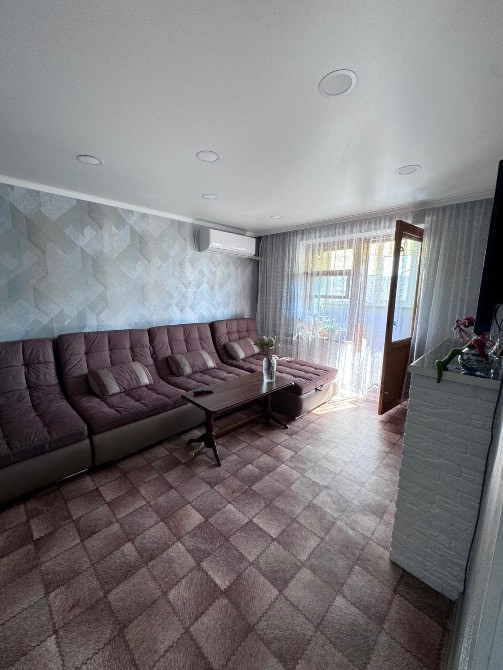 Қонақ бөлмесі диван мен балконға шығумен