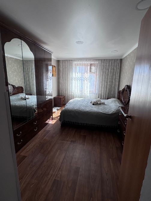 Ұйықтайтын бөлме үлкен төсек пен айналы шкафпен