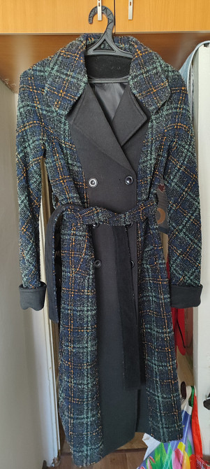 Пальто с крупной клеткой, одетое на вешалке, вид спереди