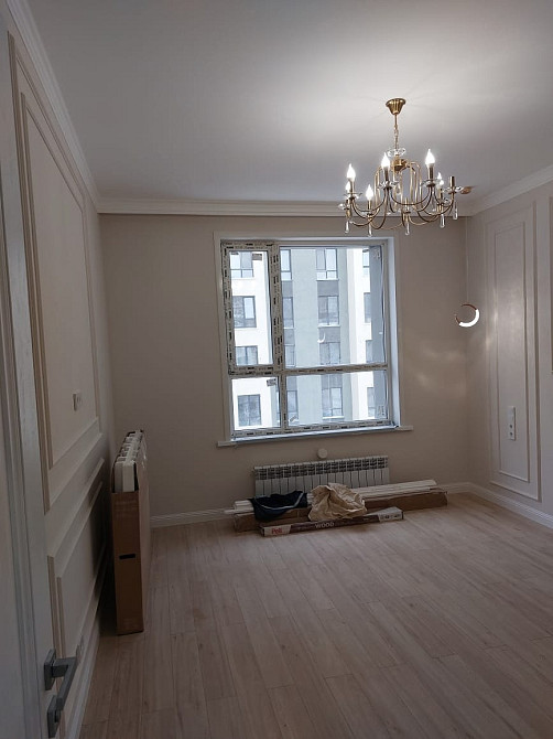 комната с окном, хрустальной люстрой и современным ремонтом