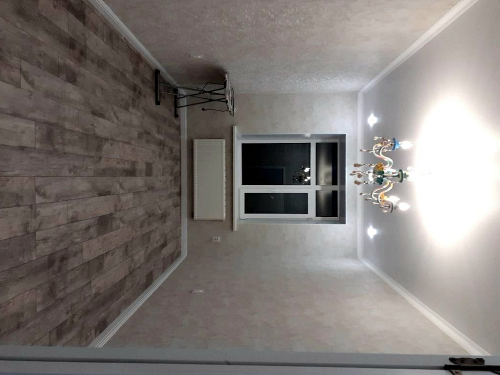 просторное помещение с окном, современным освещением и стульями