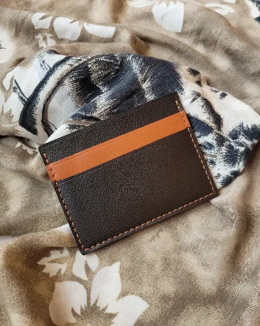 Кожаный кошелек на деревянном столе с монетами и листьями