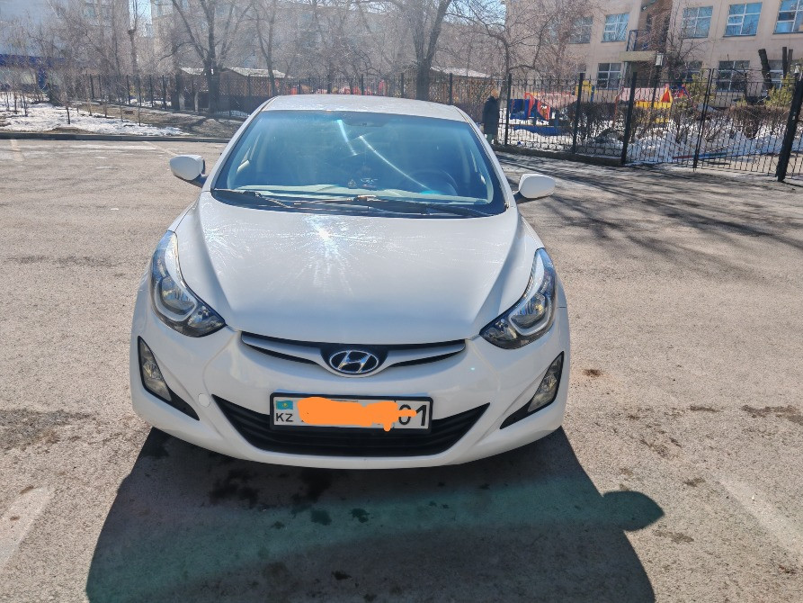 Ақ Hyundai Elantra автокөлігінің алдыңғы жағы номерлік белгісімен